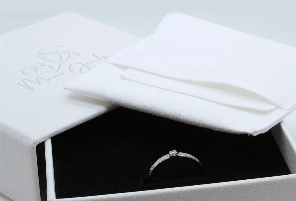 Elegante ring van massief witgoud met een sprankelende zirkonia, gepresenteerd in een luxe doos met een zachte voering.