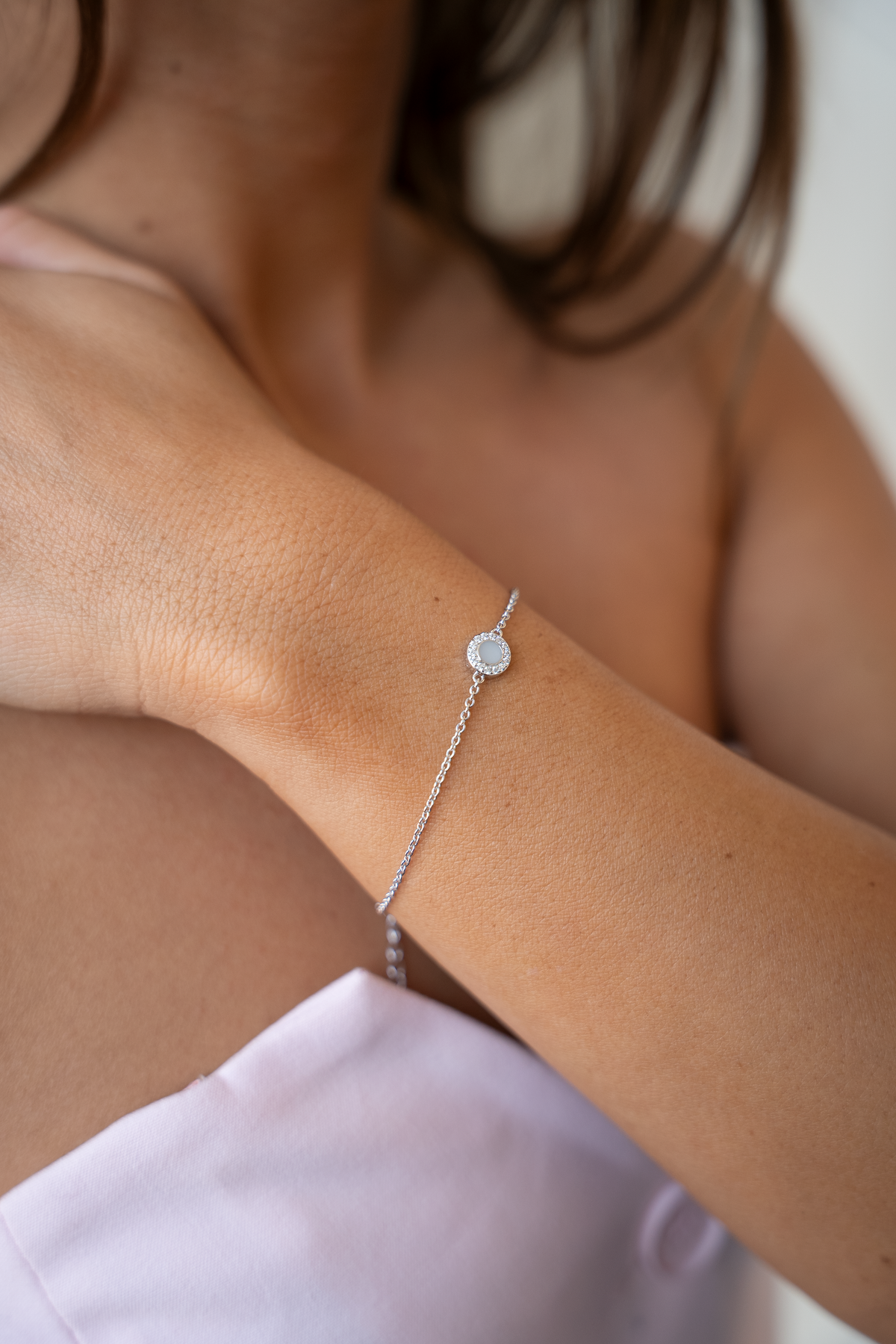 Armband van 925 zilver met een ronde schijf waarin moedermelk is verwerkt, subtiel versierd met een zirkonia.