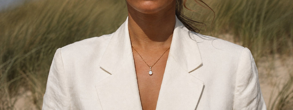 Vrouw draagt een moedermelksieraad van Mama Jewels