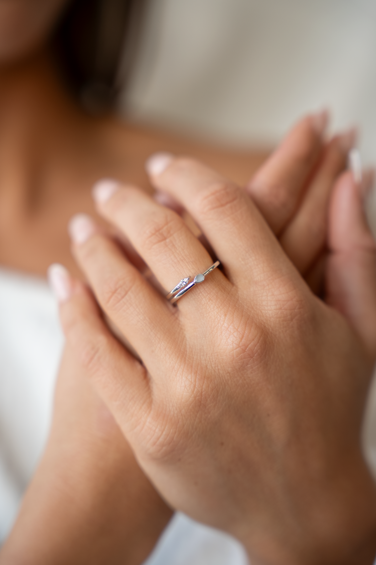 Moedermelkring van 925 zilver met een subtiele, glanzende afwerking, gedragen op een hand met verzorgde nagels.