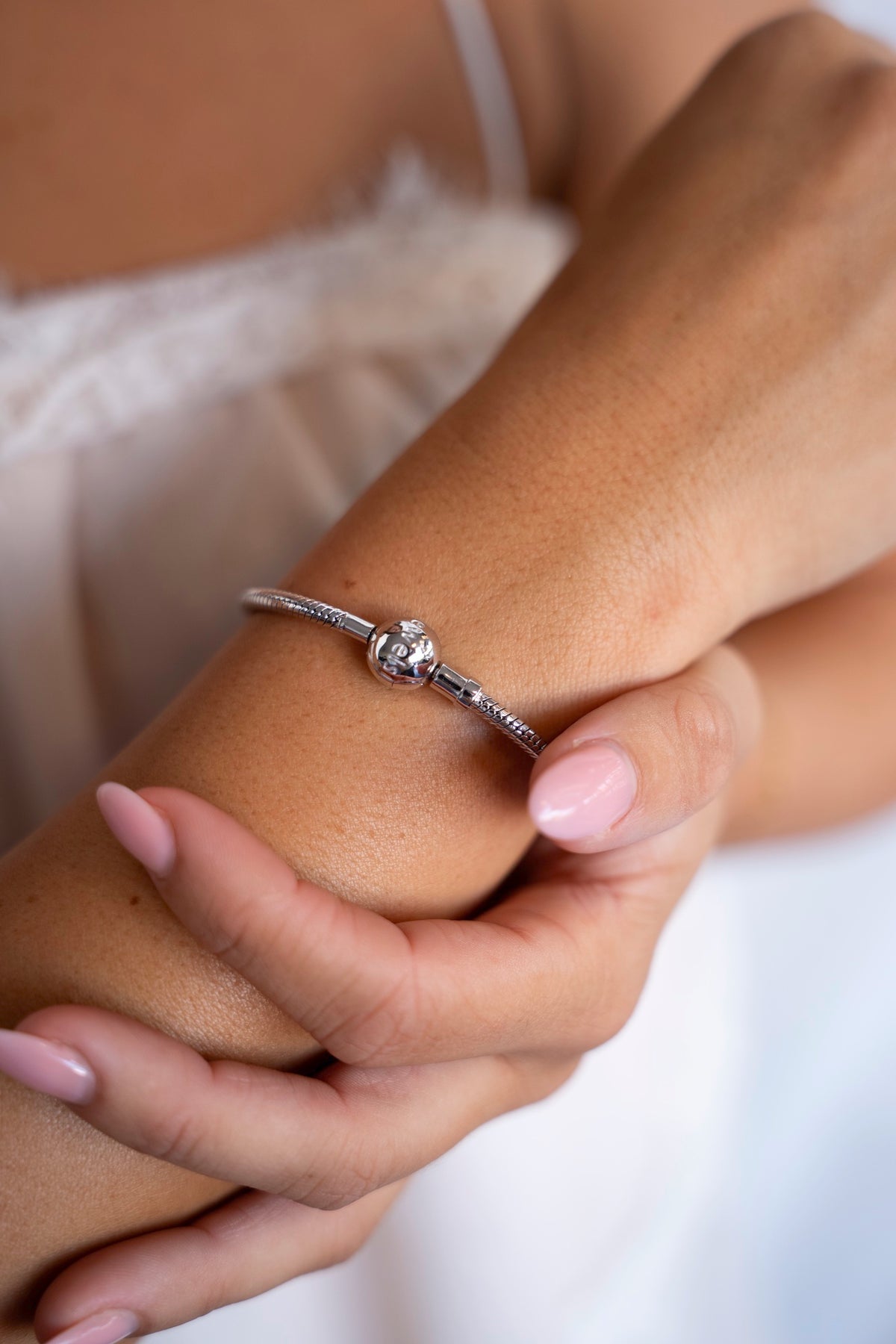 Zilveren bedelarmband met ronde sluiting om de pols, voor moedermelkbedels.